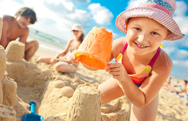 Kid building a sand castle.