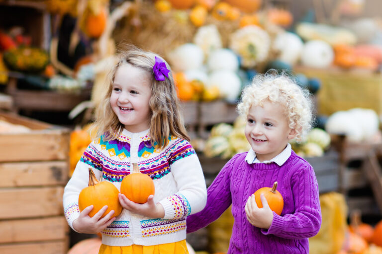 Two cute kids holding pumpkins at a Myrtle Beach October event.