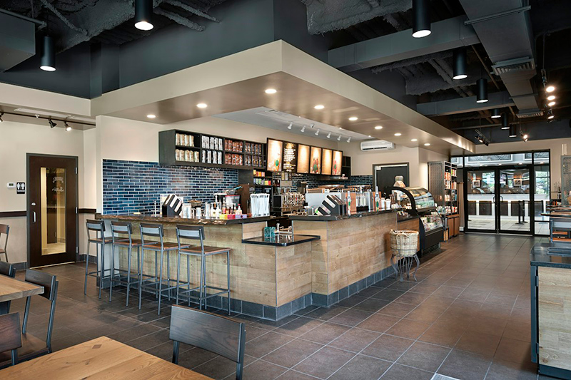 A hotel lobby bar with a counter, seating, and shelves.
